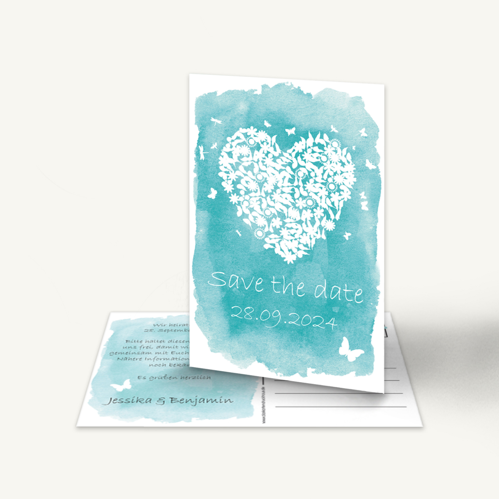 Romantische „Save the Date“-Karte im modernen Aquarell-Design, Format 11 × 17 cm als Duplex-Postkarte. Die Vorderseite zeigt einen türkisfarbenen Aquarellhintergrund mit einem großen weißen Herz, das aus kleinen Blüten, Blättern und Schmetterlingen gebildet ist. Darunter steht in weißer, handschriftlicher Schrift: „Save the date“ und „28.09.2024“. Auf der Rückseite befindet sich Platz für persönlichen Text und Adressfeld, gestaltet im gleichen Farbton. Die Karte vermittelt einen frischen, liebevollen und verspielten Eindruck – ideal, um den Hochzeitstermin stilvoll anzukündigen.