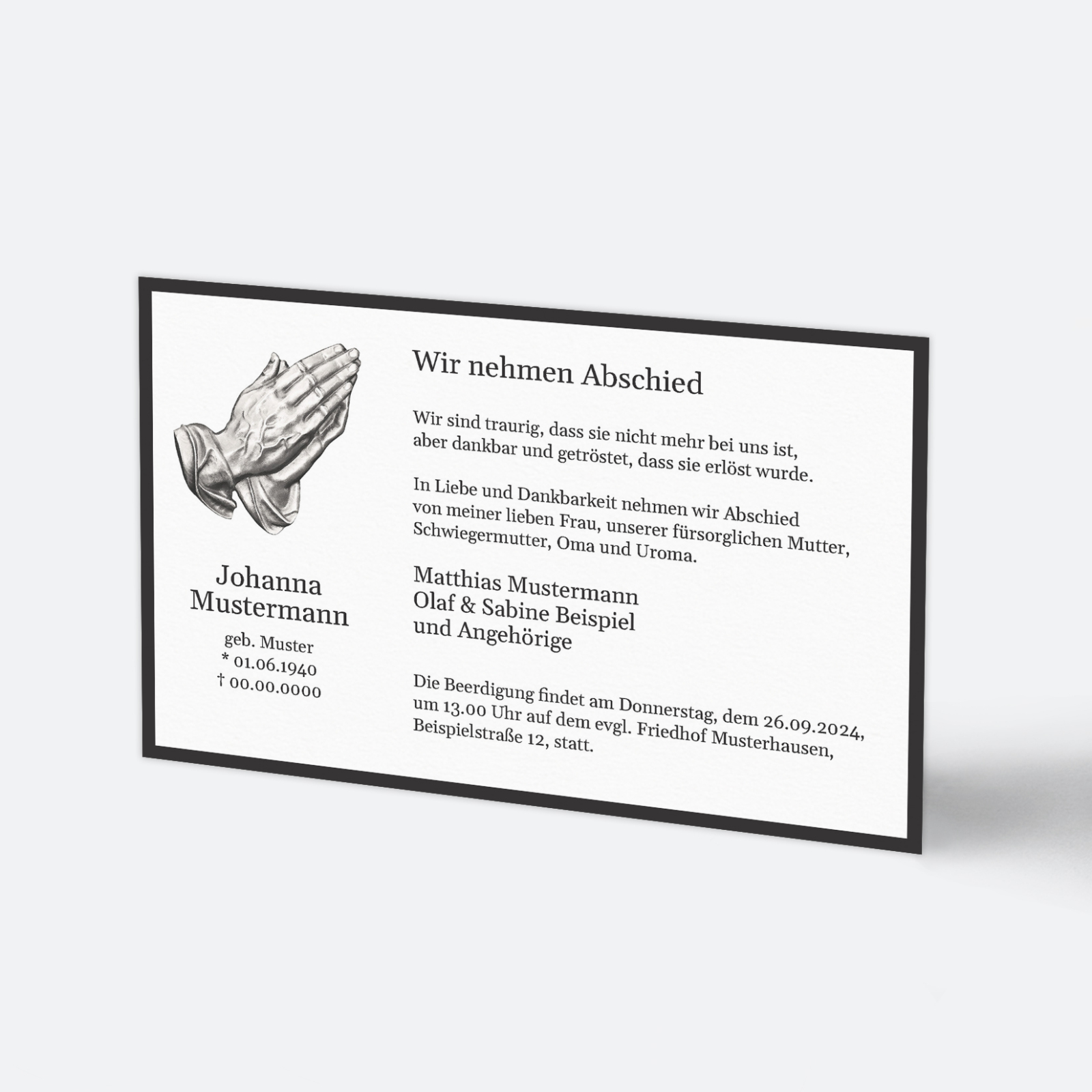 Trauerkarte im Postkartenformat 17x11 mit klassischem schwarzen Rand und Illustration betender Hände. Text: 'Johanna Mustermann geb. Muster * 01.06.1940 † 00.00.0000 ...'.